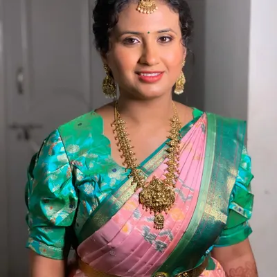 Swathi looking lovely for her sister's reception. This is a great example of a non-bridal look that is still elegant and photo-ready, featuring a pink and green saree and traditional jewelry.