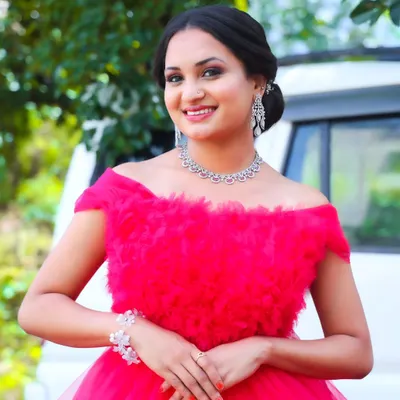 A bright, happy smile from a modern photoshoot. The makeup is glamorous yet fresh, with smoky eyes and a nude lip, letting her natural beauty shine in this stunning pink gown.