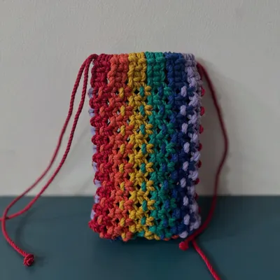 A vibrant rainbow-themed mobile pouch with a red drawstring. It's a cheerful way to protect your phone.