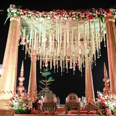 This is what I call tying the knot in style. A larger-than-life mandap with grand pillars and a canopy of hanging floral strings creates a truly royal and unforgettable setting for the wedding ceremony.