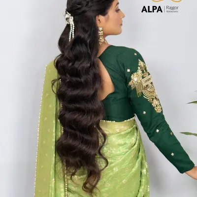 A beautiful half-up, half-down hairstyle for very long hair, featuring soft waves and a delicate braid. This look is perfect for a reception or Sangeet.