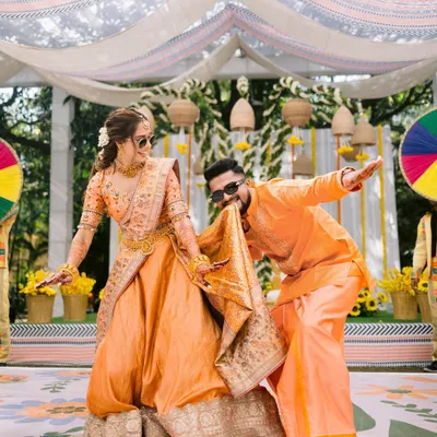 The groom playfully dances with his 'param sundari' during their Haldi ceremony. A riot of color, laughter, and love.