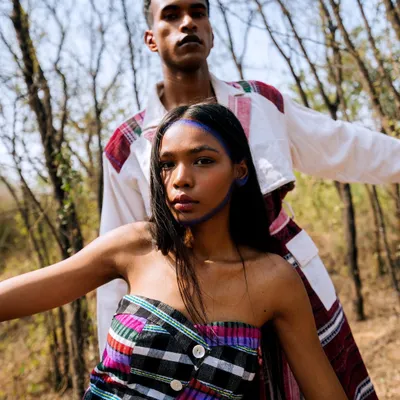 From the 'Nazaar' editorial, this outdoor portrait features two models in a strong, confrontational pose, blending fashion with a raw, natural setting.