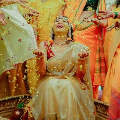 A moment of pure bliss as the bride is showered with flower petals during her Haldi ceremony. Her joyful laughter is infectious.