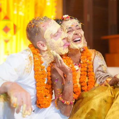 The perfect Haldi moment. This is what it's all about: pure, unrestrained laughter and the joy of being covered in love and turmeric.