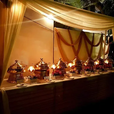 This is an example of a complete evening buffet setup for a client's celebration. I use warm lighting and elegant drapes with traditional copper serving dishes to create a festive and inviting dining experience.