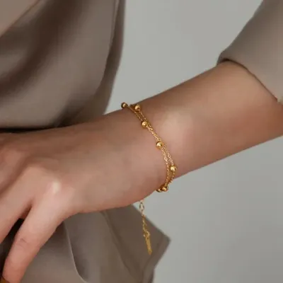 A delicate double-strand beaded bracelet shown on the wrist. This piece is made from tarnish-resistant stainless steel and is perfect for everyday wear.