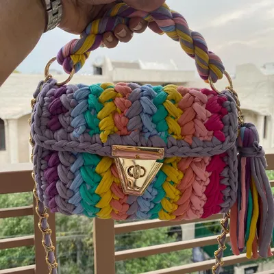 This is my crochet "marshmallow" bag in a vibrant rainbow design. It's made from soft T-shirt yarn and is surprisingly lightweight, with a chunky gold chain that makes it a real statement piece.
