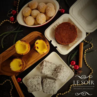 A festive flatlay of my Christmas 2024 menu. This spread includes eggless treats like Portuguese Pastel de Nata, Australian Lamingtons, mini fruit cakes, and doughnuts.