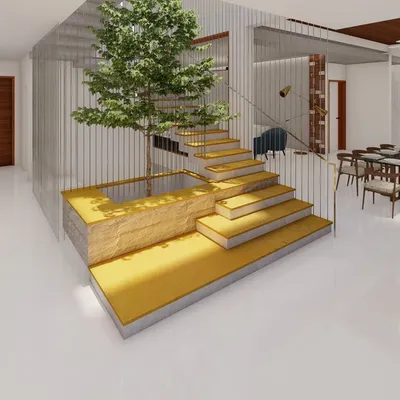 A double-height courtyard is the centerpiece of this home, featuring a staircase that appears to float over a Jaisalmer yellow stone base. A living tree grows within the space, reaching towards the skylight above.