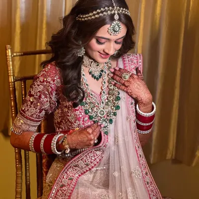 This bride's soft girl look is pure perfection. The makeup is minimal and dewy, with a focus on glowing skin and soft pink tones to complement her pastel lehenga.
