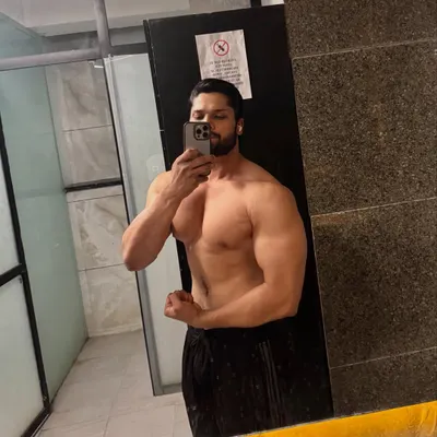 A shirtless mirror selfie showing chest and arm development. This is what being an absolute unit looks like.