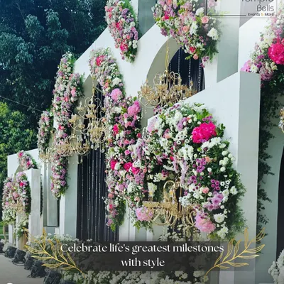 An opulent floral facade we created for a luxury wedding event. This design features cascading bouquets of pink and white flowers accented with golden chandeliers, transforming a simple wall into a breathtaking photo opportunity.