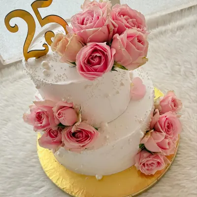 A stunning two-tier cake for a 25th anniversary, decorated with dozens of fresh pink roses. The design is classic, romantic, and perfect for such a special milestone.