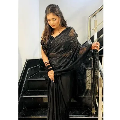A stunning black sequined saree, perfect for a cocktail night or reception party. The sheer fabric and all-over sparkle create a look that is both elegant and glamorous.