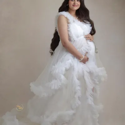 This full-length portrait in a flowing white ruffled gown creates such an angelic and ethereal feel. In the studio, we can play with fabrics and poses to create fine-art maternity images that look like they belong in a gallery.