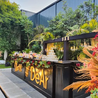 Our elegant black bar setup, decorated with florals and a custom hashtag, is perfect for sophisticated outdoor weddings and receptions. It provides a chic and personalized focal point for your guests.