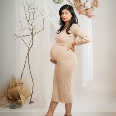 A simple, elegant portrait in a comfortable ribbed dress. The neutral tones and minimalist set design create a modern and timeless look that focuses on the beauty of the mother-to-be.