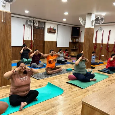 A group of students practicing Brahmari Pranayama, or the Humming Bee Breath. This calming technique uses sound vibration to soothe the nervous system, reduce stress, and quiet the mind.