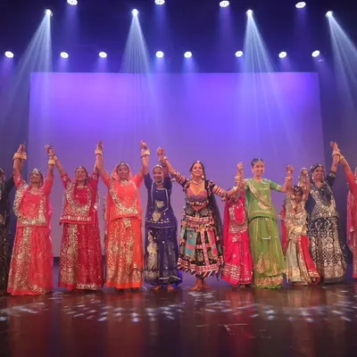The final bow after a grand stage performance. This moment of unity with all the dancers holding hands captures the spirit of teamwork in our group choreographies.