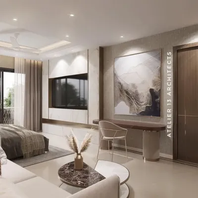 This master bedroom combines a cozy bed with a functional workspace. The TV unit is crafted from white marble with brass inlay, and a large abstract artwork adds a touch of modern sophistication to the serene space.