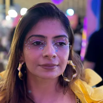 A client looking radiant with a custom silver glitter and gem design under her eyes, perfect for the Coachella party vibe.