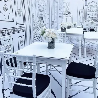 A closer view of the 2D cafe theme, where even the tables and chairs are outlined in black to create a surreal, hand-drawn effect.
