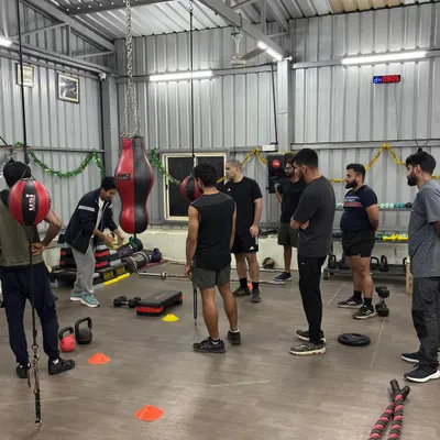 Every session starts with a clear briefing. Here, a senior trainer demonstrates the exercises for the day's circuit, ensuring everyone understands the movement and its purpose before we begin.