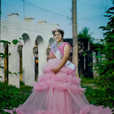 A full-length view of our pink ruffle gown, perfect for a baby shower or maternity shoot. The layered ruffles create a beautiful, full skirt that looks stunning in photos.