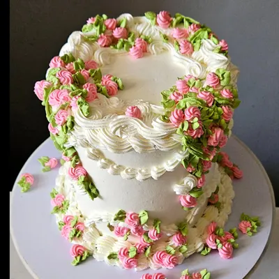 A celebration of spring and vintage piping. This whipped cream cake is covered in hand-piped floral climbers and delicate shell borders, a classic technique that brings timeless beauty to any occasion.