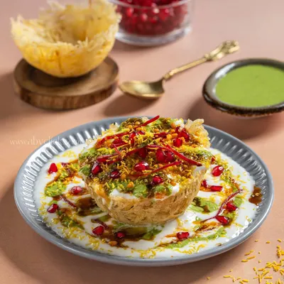 A stunning Raj Kachori from Gulab Sweets, overflowing with yogurt, chutneys, and sev. The styling makes it look like a royal street food dish.