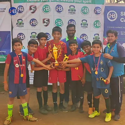 Champions of the turf. A young football team celebrates with their trophy after a hard-fought victory in a tournament organized by us.