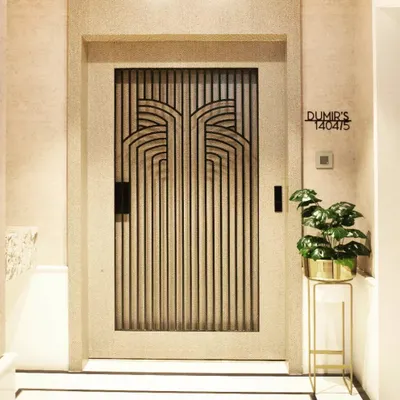The entrance door to the Dumir's 5BHK apartment in Mulund. The Art Deco-inspired metal grillwork on the door makes a powerful first impression before you even step inside.