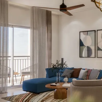 A look into the living area of our Prestige Waterford project. The deep blue L-shaped sofa adds a pop of color, while the sheer curtains allow for ample natural light, creating a space that is calm yet confident.