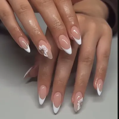 A classic French manicure with a delicate, hand-painted white flower. This is such a timeless and elegant look, perfect for any occasion.