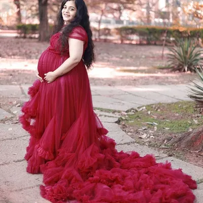 This stunning red tulle gown is a favorite for maternity photoshoots. Its long, ruffled trail creates a dramatic effect, while the comfortable design beautifully accommodates your baby bump, making it a perfect rental for capturing those precious memories.