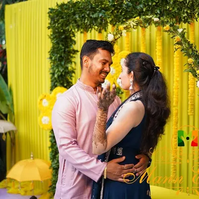 A happy couple shares a moment during their Haldi ceremony. We created a vibrant yellow backdrop with marigold floral arrangements to match the joyous and energetic spirit of the event.
