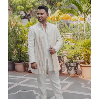 For this event, I designed a custom ivory kurta set for the groom, paired with a structured, striped jacket for a look that is both traditional and modern.