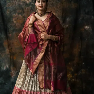 A full-length portrait showcasing a magnificent traditional lehenga. The painterly backdrop and soft lighting create a regal atmosphere, emphasizing the elegance of the attire.