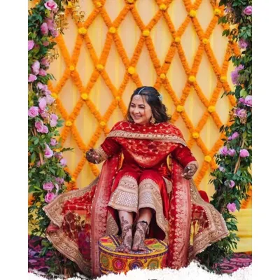 Here is a beautiful mehendi setup I did, with the bride seated for her ceremony. The backdrop is a lattice of orange marigolds against yellow drapes, framed by columns of fresh pink flowers and green leaves.