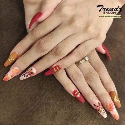 This set is a true work of art. On these long, dramatic stiletto nails, I combined matte red, warm brown, and intricate abstract floral patterns with gold foil accents for a bold and artistic statement.