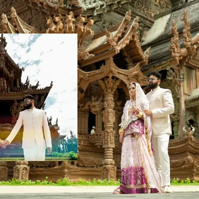 A grand portrait of a couple in traditional attire at the Sanctuary of Truth in Pattaya, Thailand, showcasing the scale of a destination shoot.