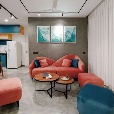 The living room of the T7 & T8 apartment features a custom blush-colored sofa that provides a beautiful pop of color against the grey textured wall and polished concrete floor.