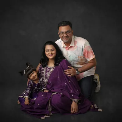 Every family has a story, and I love capturing yours. This beautiful studio portrait includes the couple's older daughter, all in matching purple, celebrating their growing family.