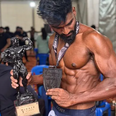 Holding the hardware. After going from zero to champion, this client proudly displays his trophy and medal from the Valarworld competition.