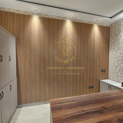 Here is a perfect example of how natural wood-finish WPC louvers can bring warmth and texture to an office or reception area. The vertical lines make the space feel taller, and the downlights highlight the beautiful panel details.