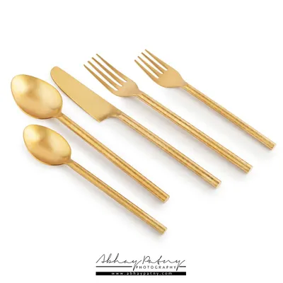 A clean, minimalist e-commerce shot of a golden cutlery set on a white background. This type of photography is essential for product listings on Amazon, Flipkart, or your own brand website.