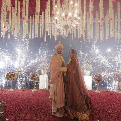 A picture of pure magic. I design spectacular moments like this, with the couple framed by cascading florals and a dazzling display of cold pyros, making the wedding ceremony feel like a scene from a movie.