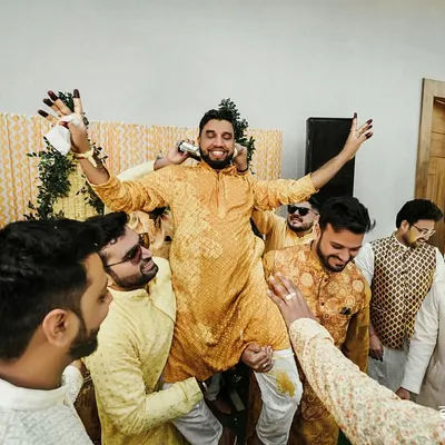 The groom is lifted up by his friends during the Haldi ceremony. These are the moments of friendship and celebration that make weddings so special.