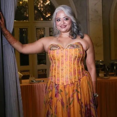 The final look for a stunning bride's cocktail event. Her natural silver hair is styled into elegant waves, paired with makeup that makes her glow.